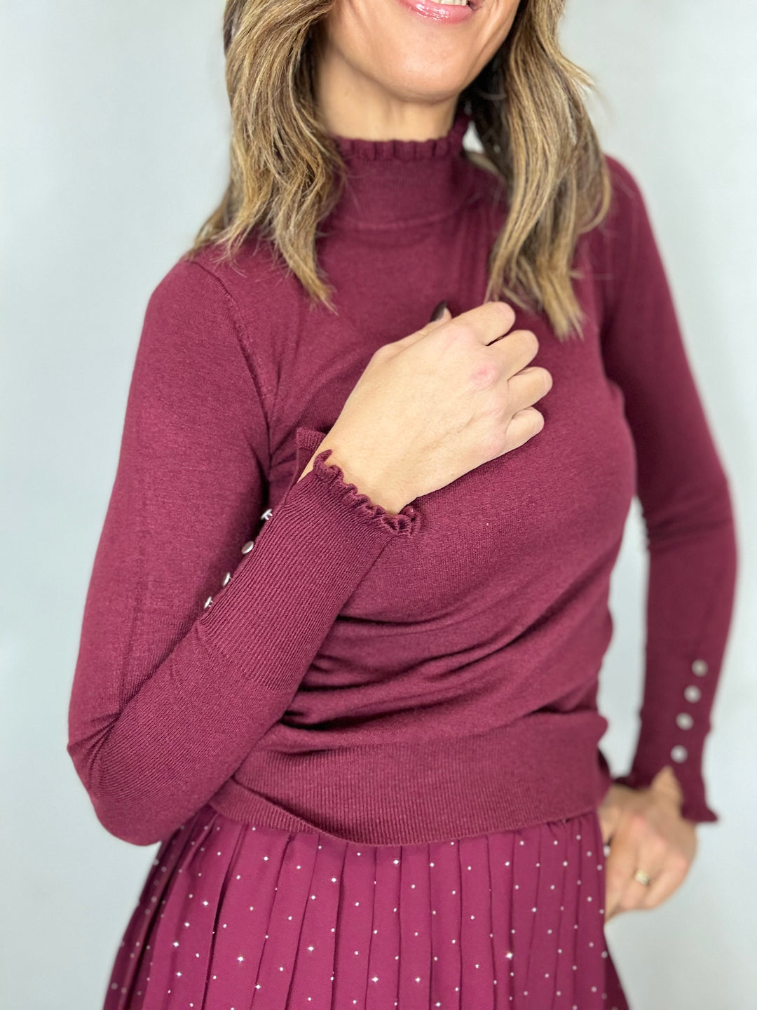 Il pull dolcevita con i fru fru e i bottoncini