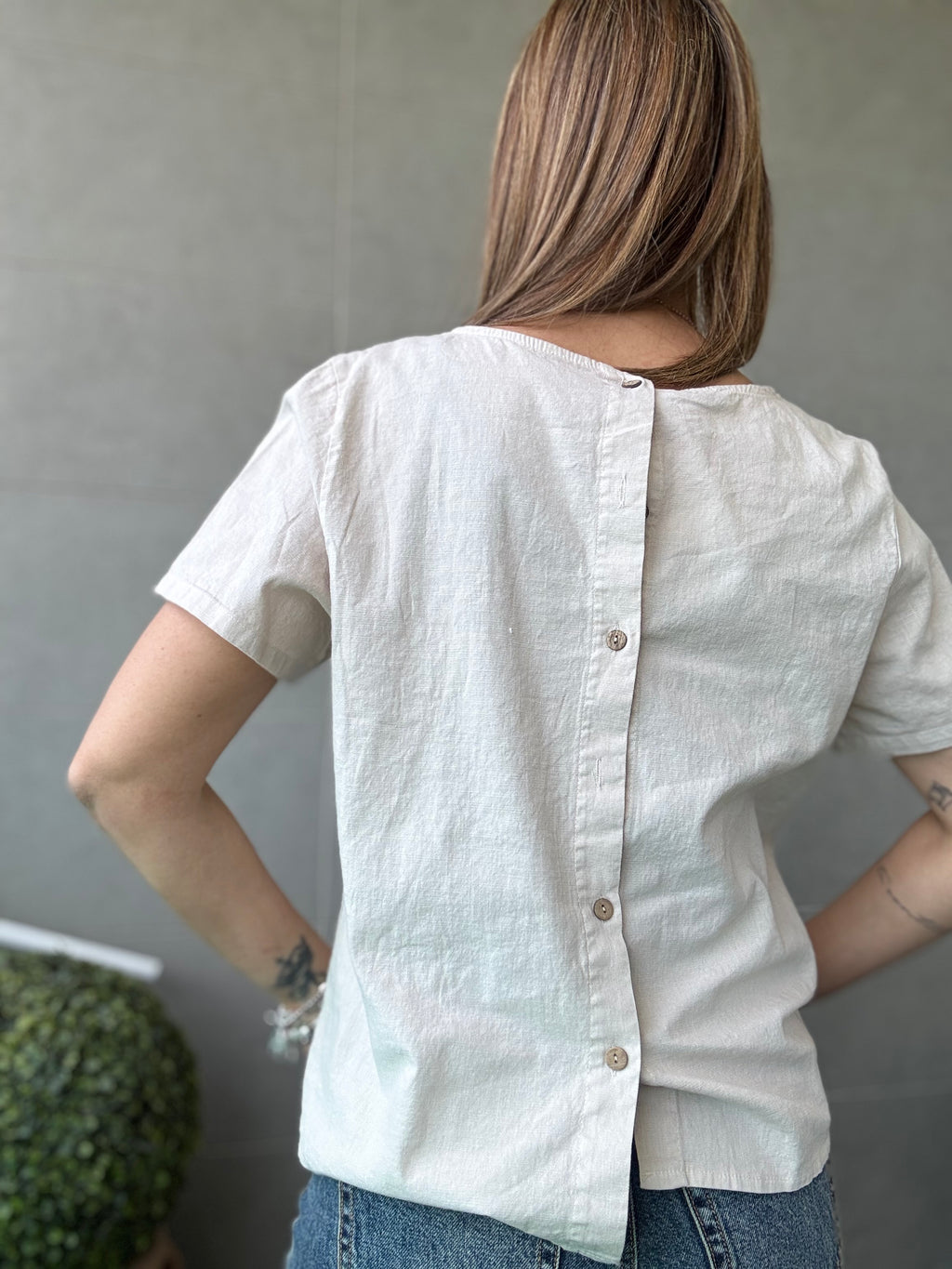 La blusa di cotone coi bottoncini dietro